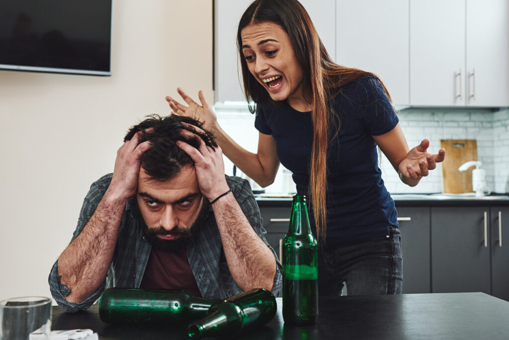 An image showing a wife shouting at her husband with frustration evident on her face. This visual represents the strain in relationships caused by addiction, highlighting the emotional turmoil and conflict that can arise within families affected by substance abuse.