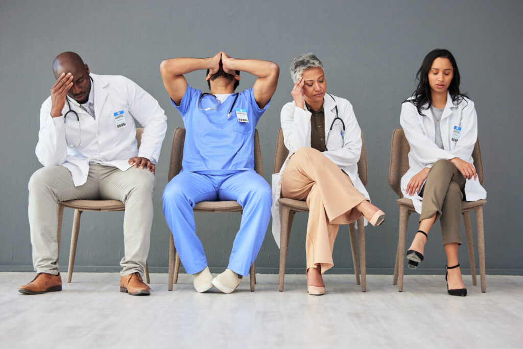  Image showing a group of frustrated and overworked doctors and nurses, highlighting the strain of addiction on healthcare systems.