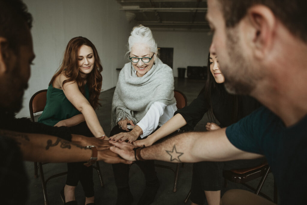 Image of a diverse group of individuals in a support group, displaying empathy and support for each other. Their expressions and body language convey understanding and solidarity, illustrating the cultivation of empathy in addressing social stigma related to mental health and addiction.