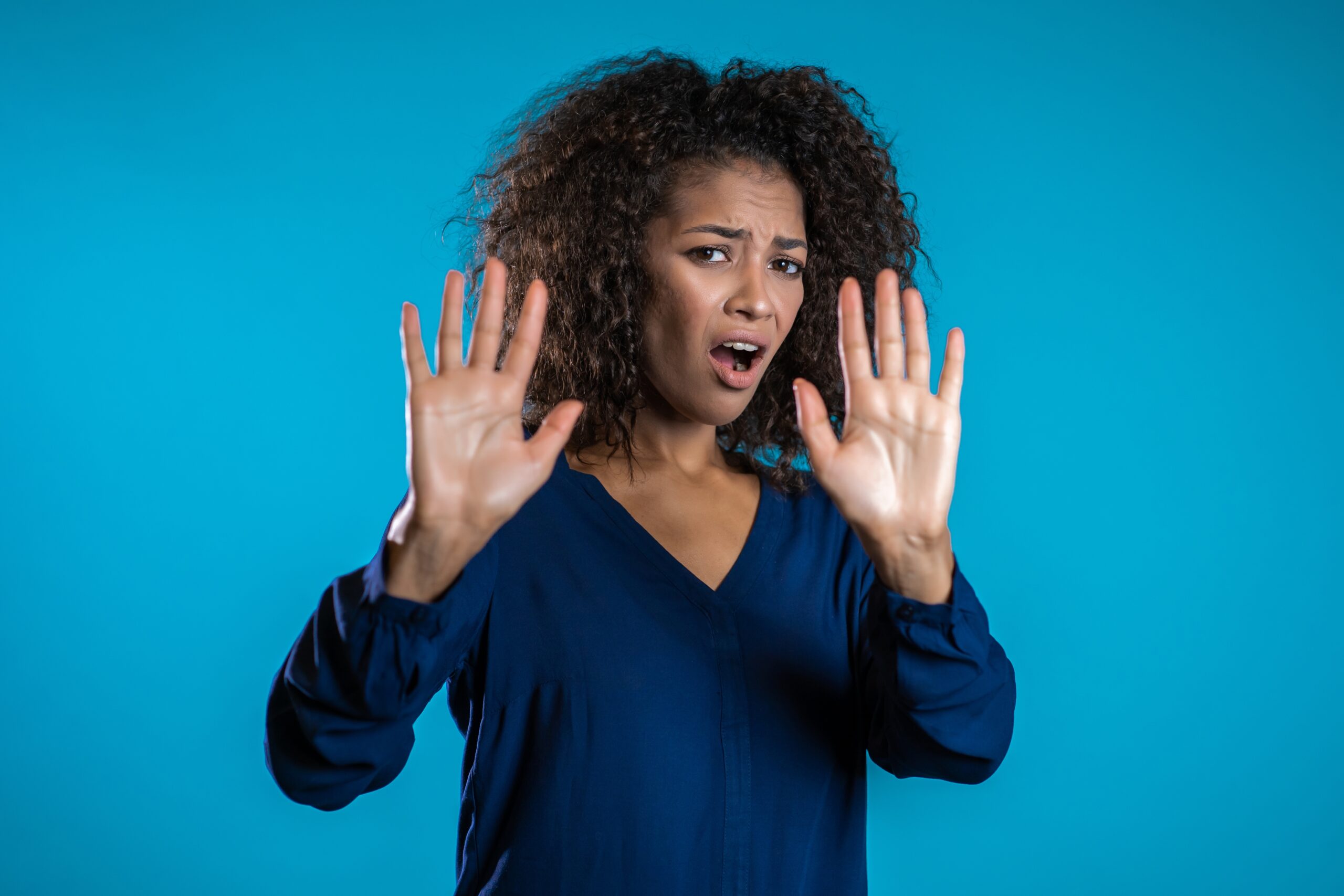 An image depicting a woman extending her hand in a stopping gesture to signify rejection, visually capturing the emotional weight and complexity of the fear of rejection in personal relationships.