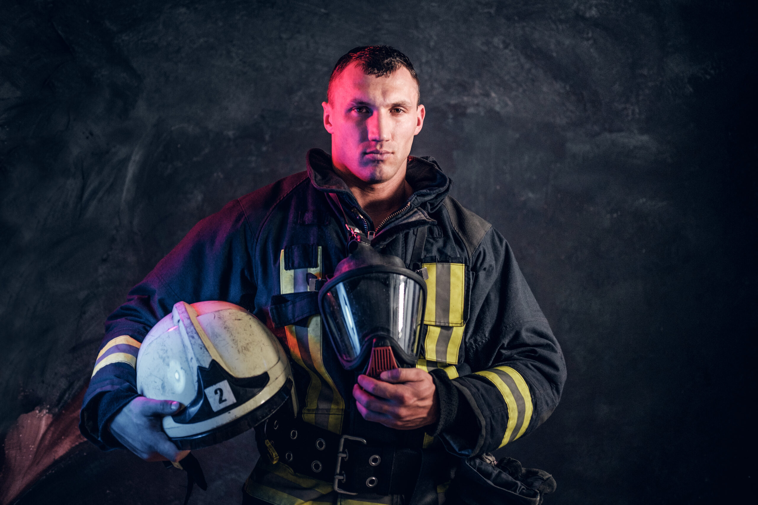 A firefighter holding his helmet in his hands, symbolizing the challenges and vulnerabilities faced by first responders in combating addiction risk.