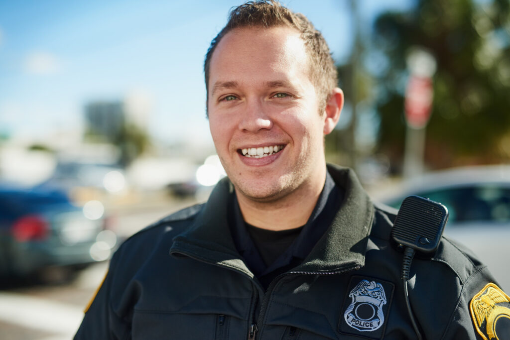 A smiling police officer stands confidently, symbolizing mental strength and resilience. This image accompanies the section of the blog discussing comprehensive mental health initiatives in policing.




