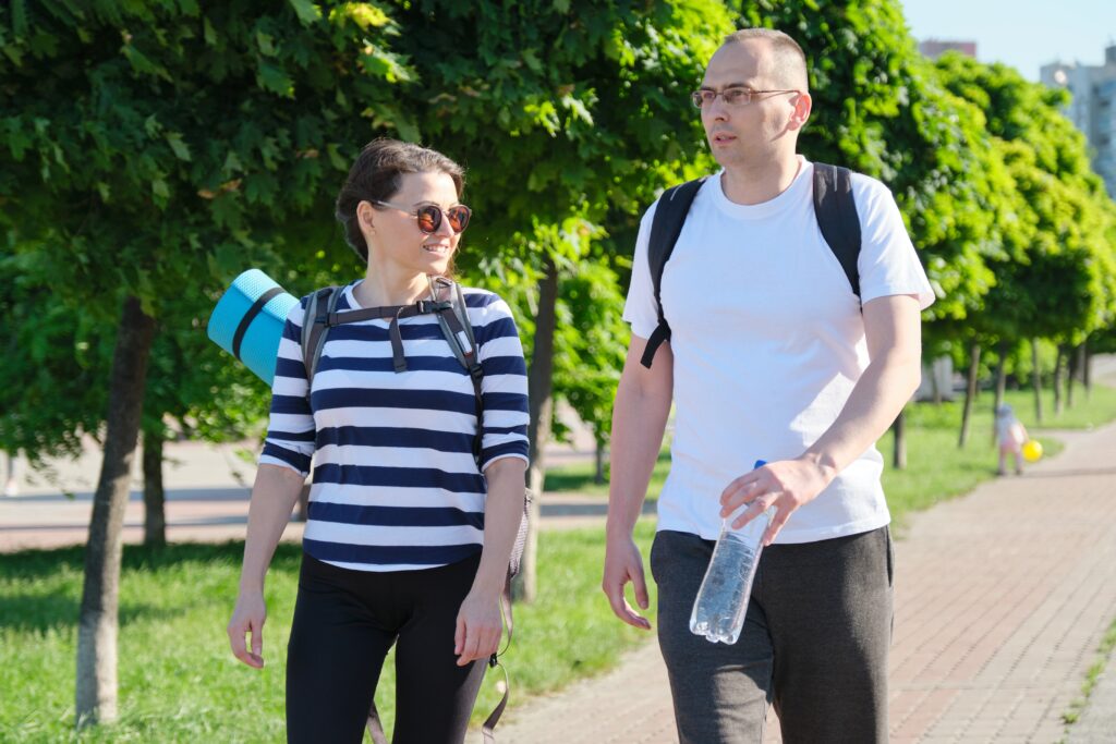Two colleagues take a stress-relieving walk, discussing ways to prevent burnout.