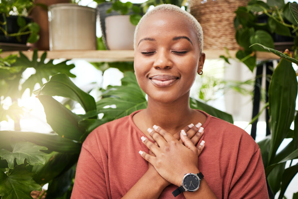 Woman practicing self-compassion with hands over heart and eyes closed, embodying inner peace