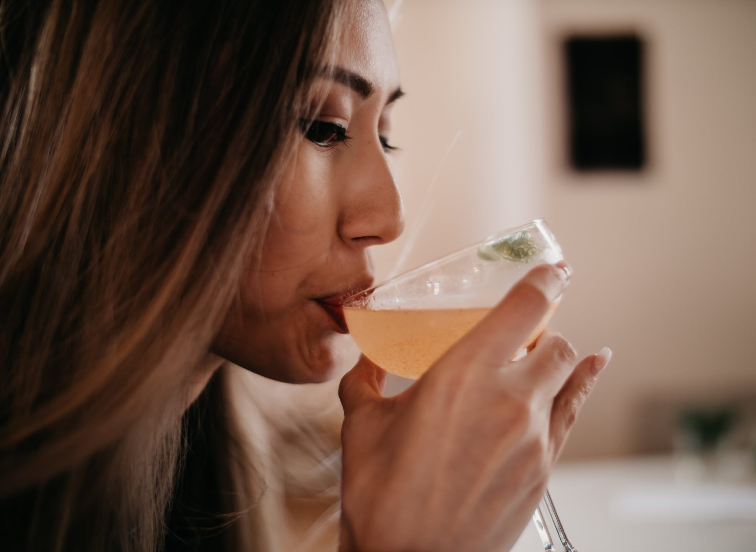 A woman sipping from a martini glass, reflecting contemplation and nuanced emotions, symbolizing the complexities of gray area drinking.