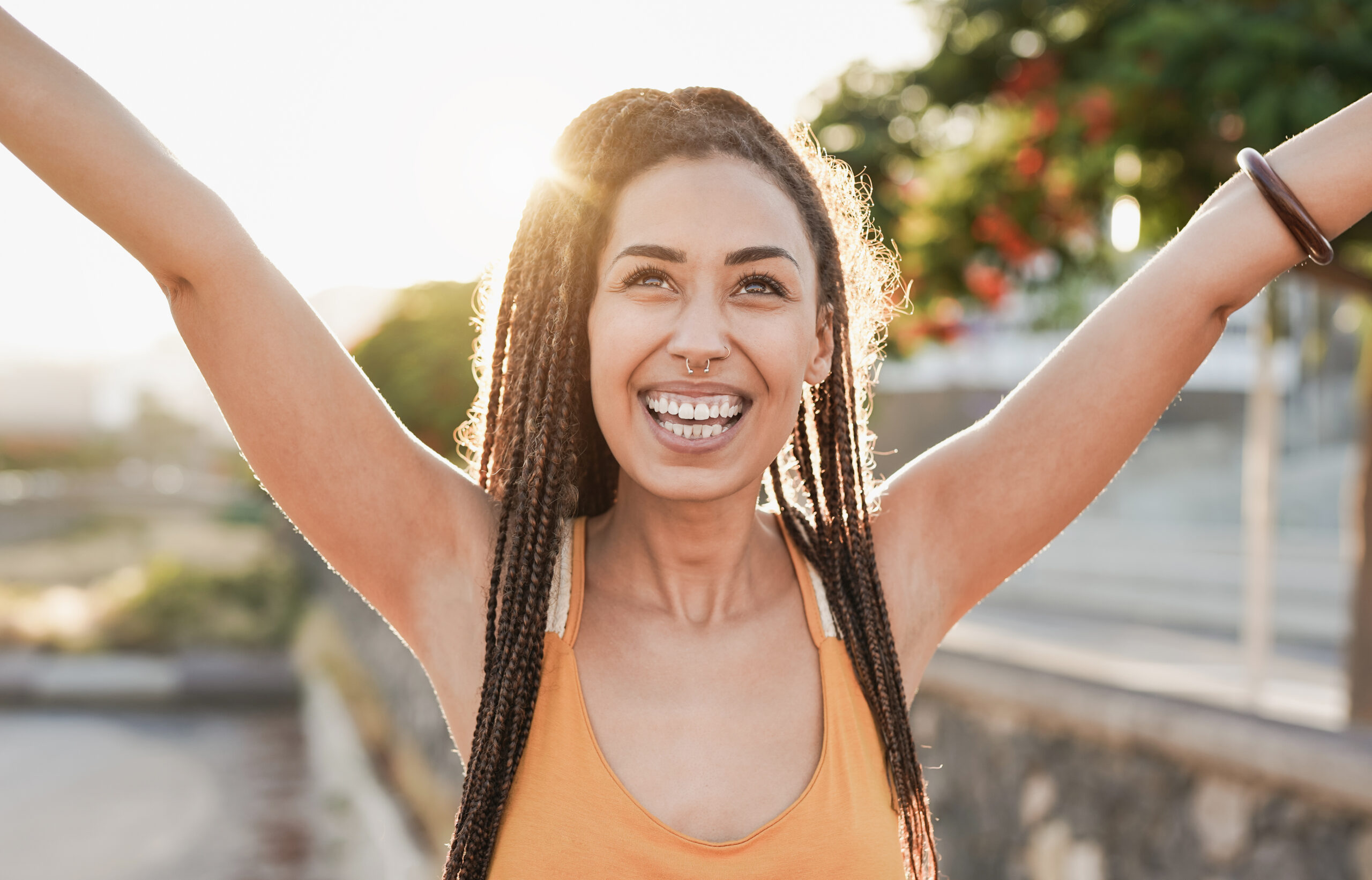 Woman with hands raised in celebration against a sunset, symbolizing joy and freedom after quitting drinking.