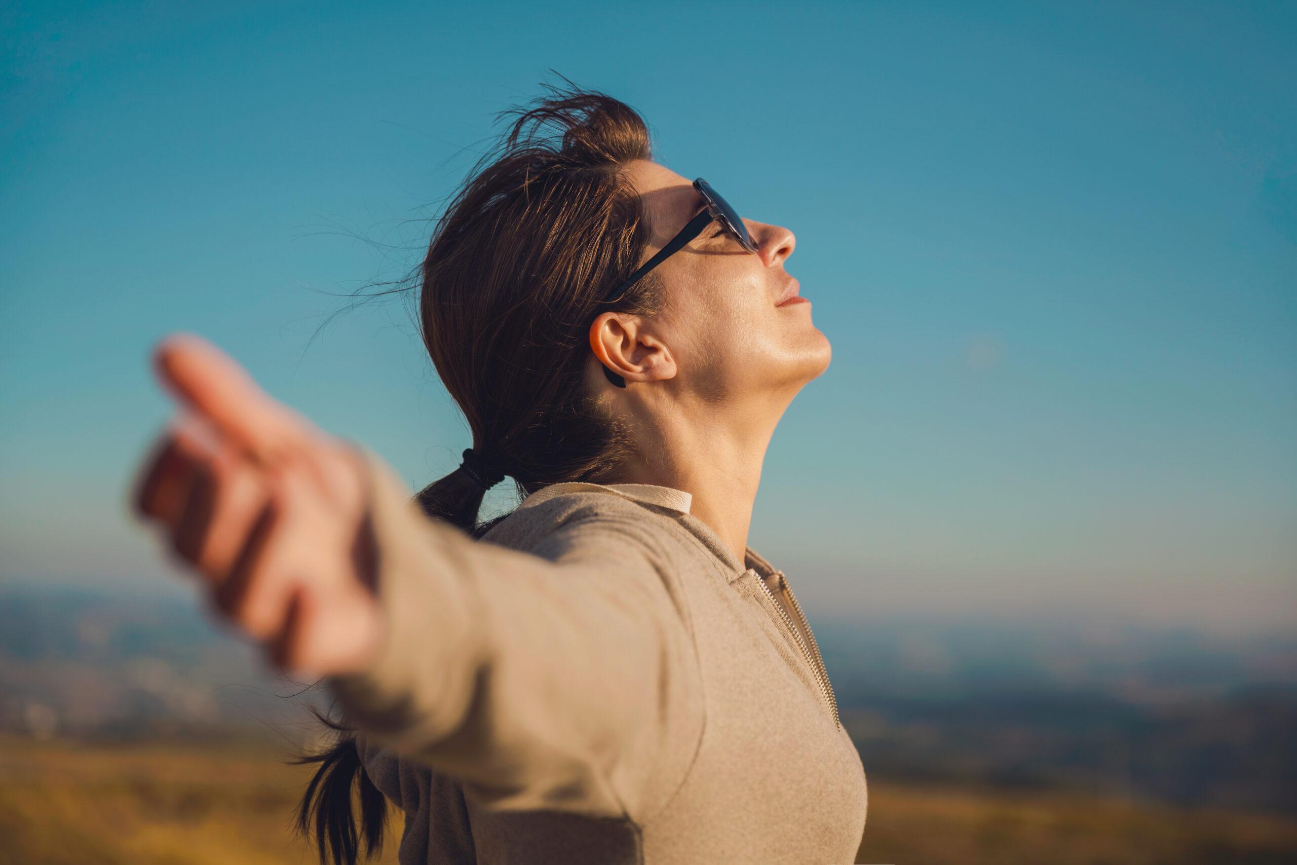 A woman with her hands outstretched, symbolizing the transformative power of therapy in her life.