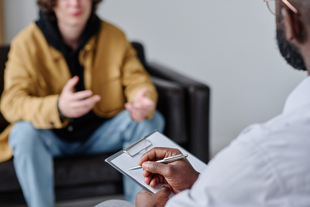 A therapist attentively listening to a patient during an initial evaluation session, illustrating the diagnosis and evaluation process for mental health disorders.