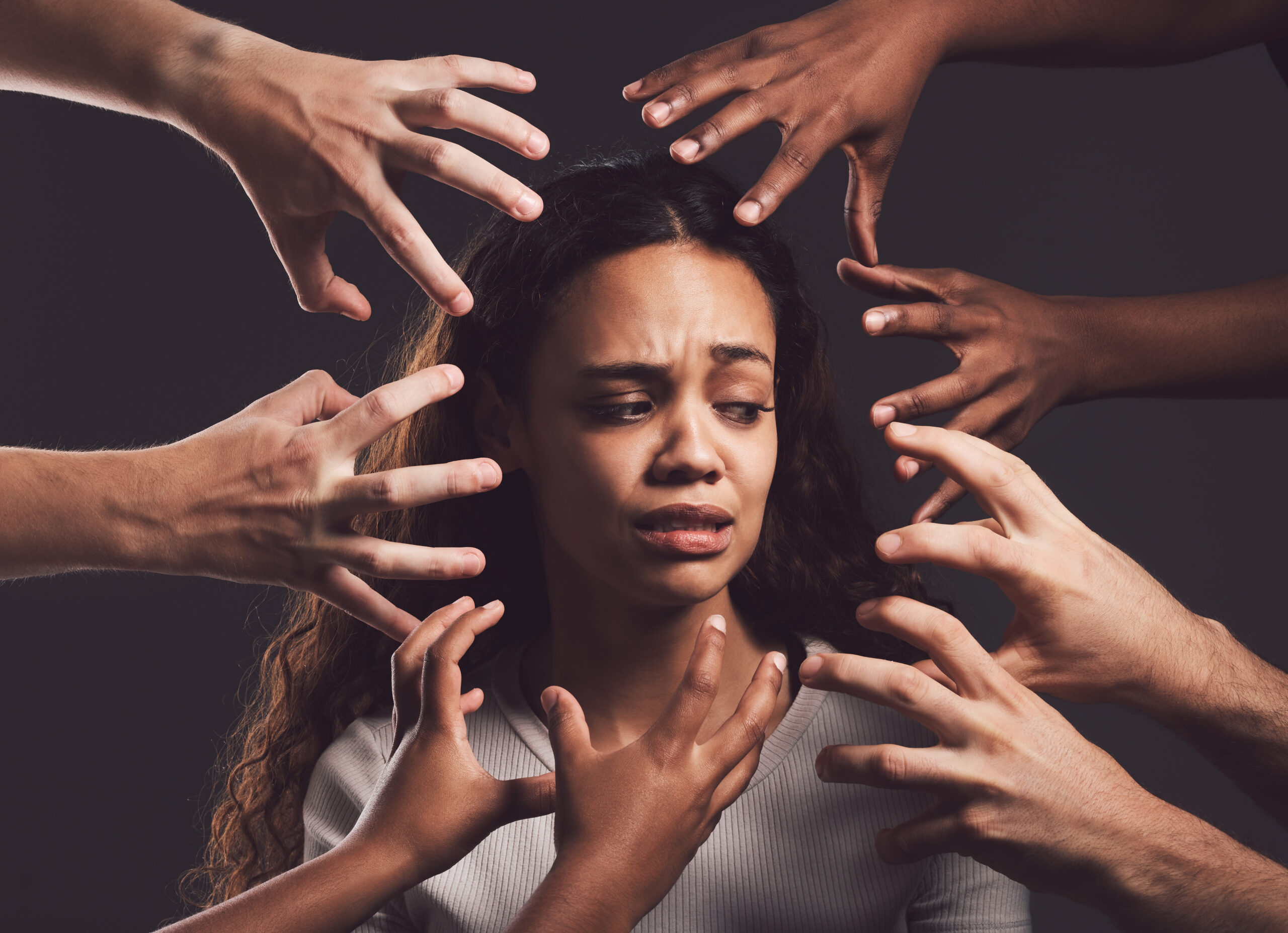 A woman surrounded by hands reaching from every direction, symbolizing the struggles of understanding mental health disorders.