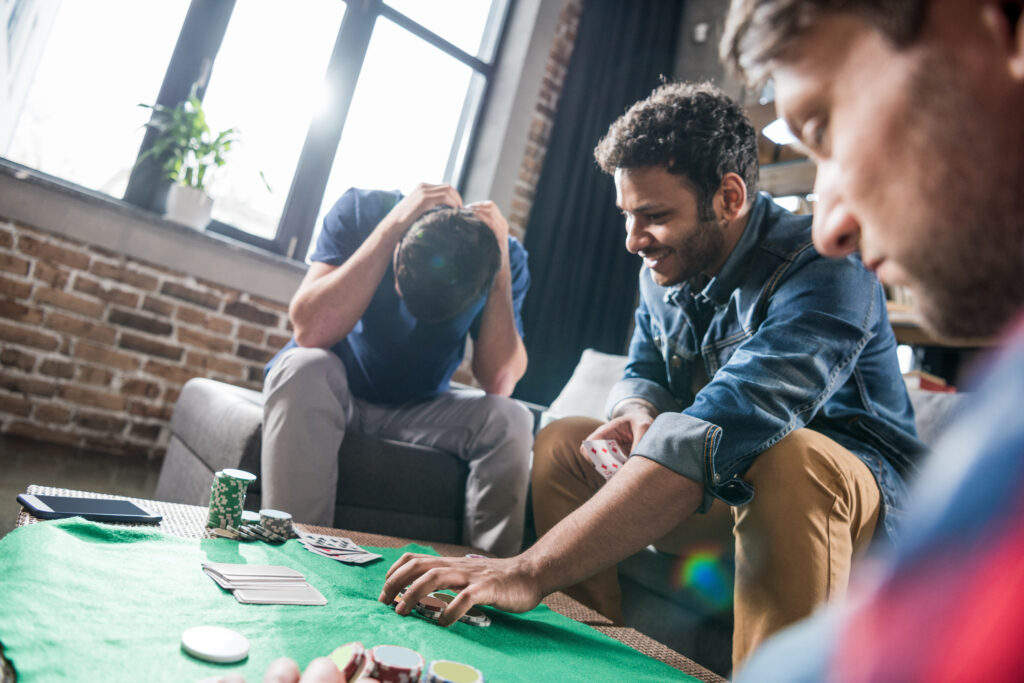 A man struggling with a gambling addiction, sitting with his head in his hands, representing behavioral addiction.