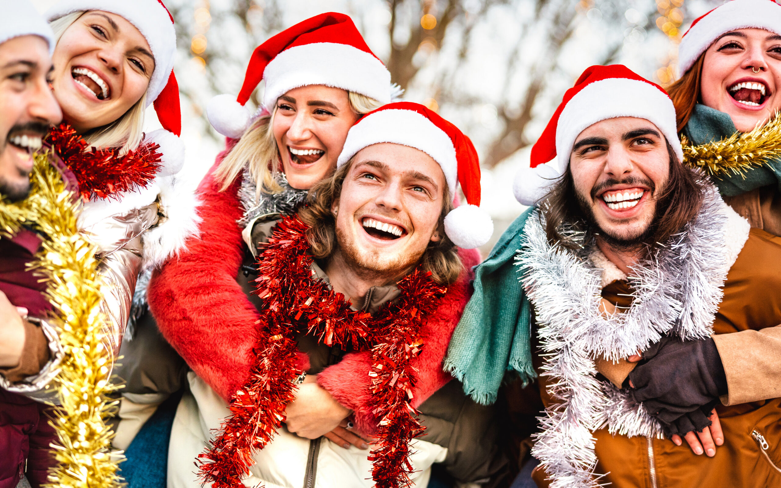 A group of friends in festive holiday outfits and Santa hats, enjoying a joyful, sober celebration, symbolizing the importance of staying sober during the holidays.