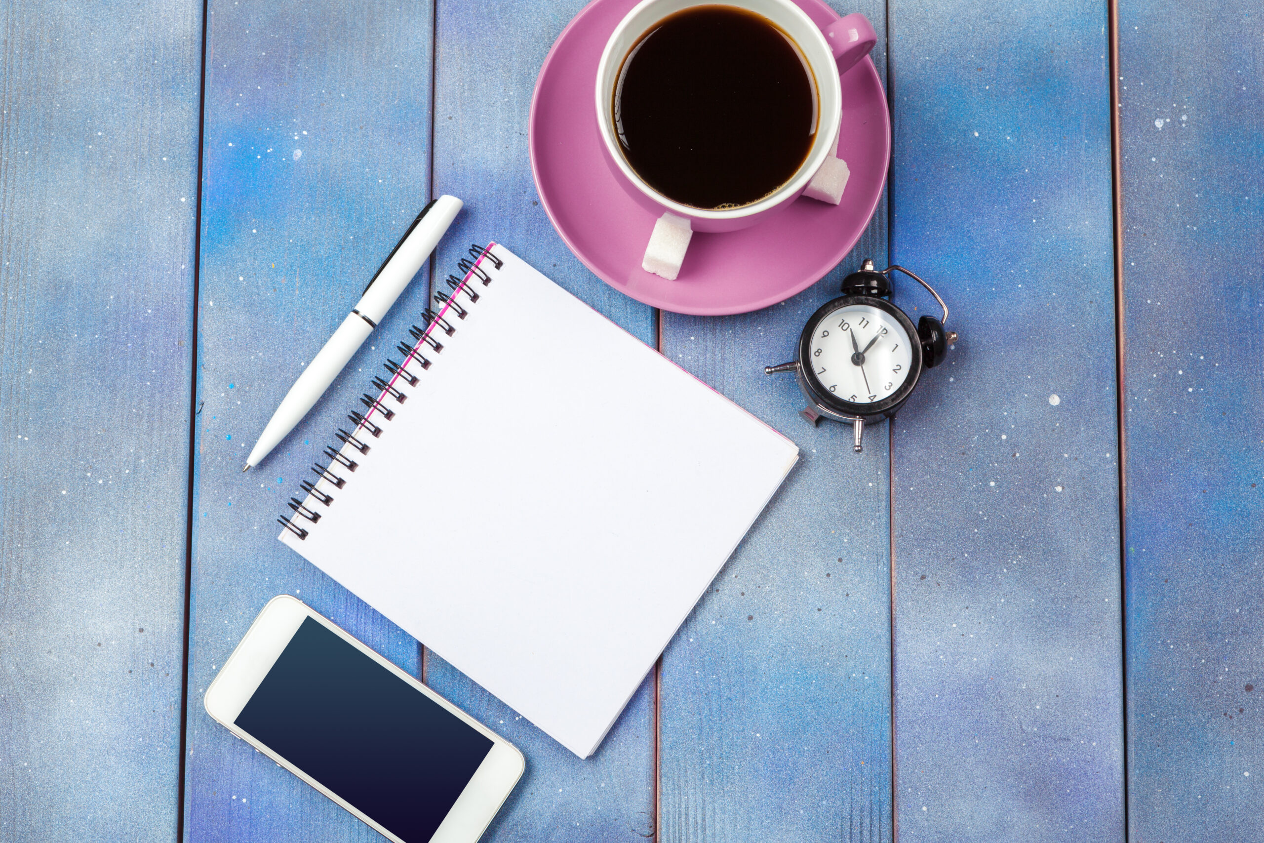 Phone placed face-down next to a journal and mug, symbolizing digital boundaries and intentional living